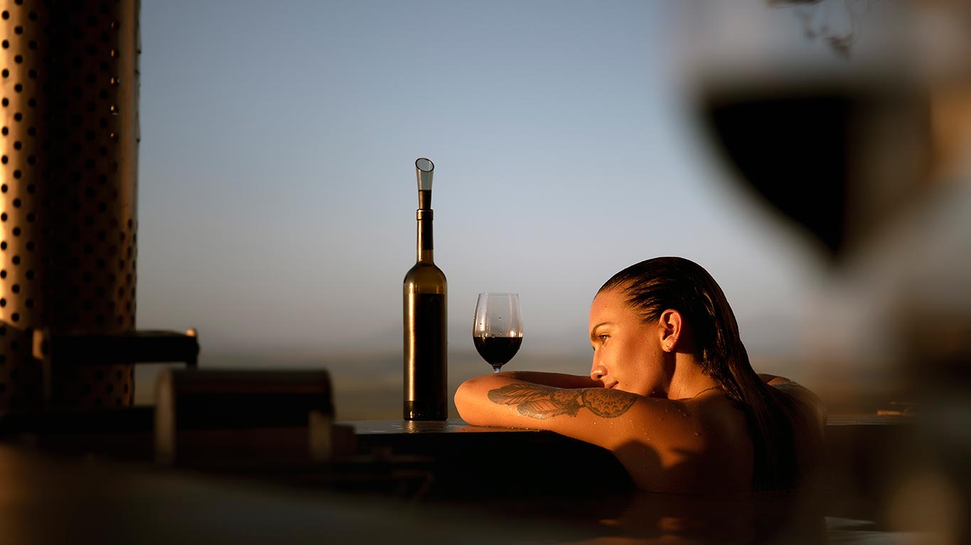 Woman looking at sunset in North Devon from hot tub in Holiday Cottage