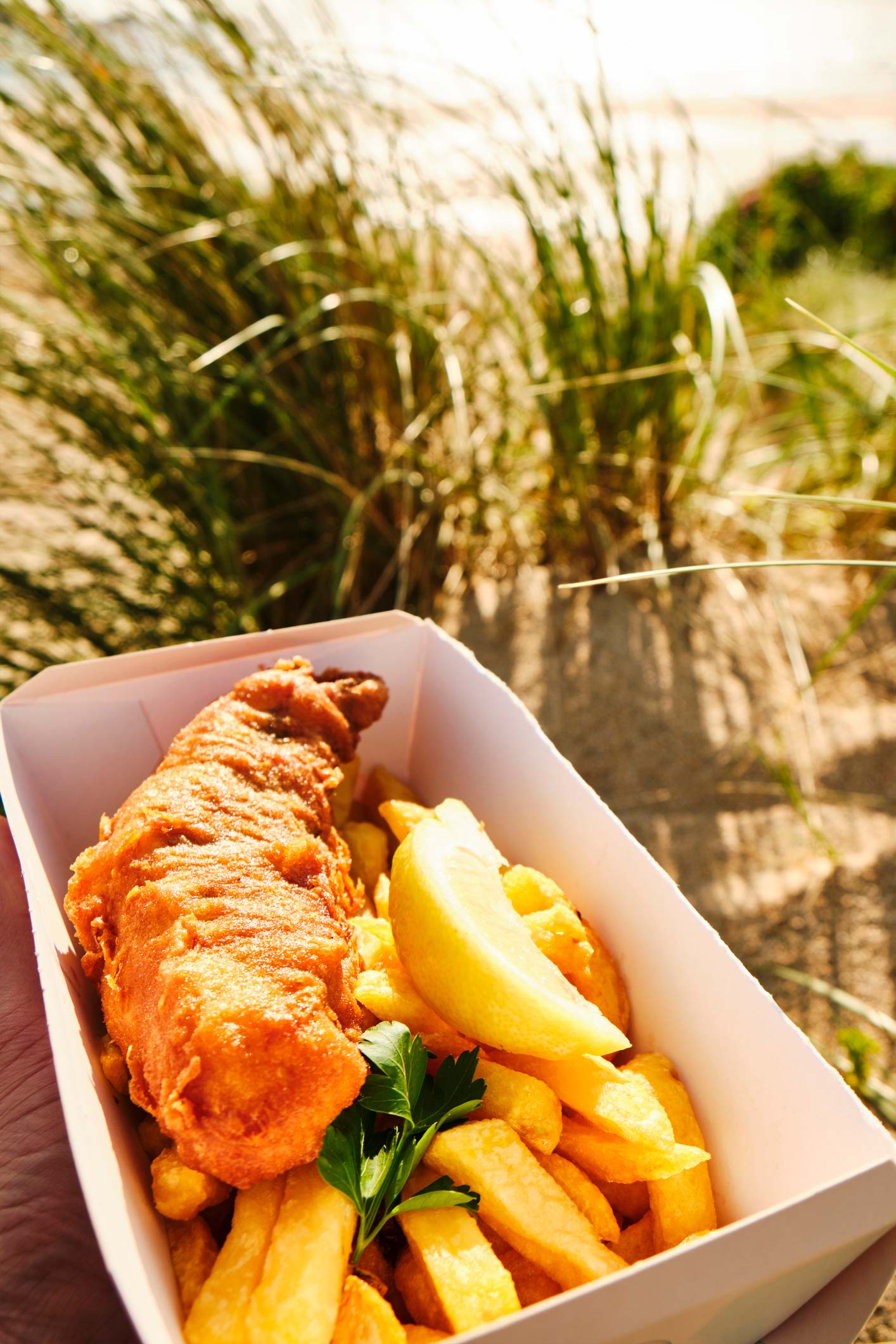 Box of Fish and Chips at Woolacombe Beach, North Devon, on a summer evening